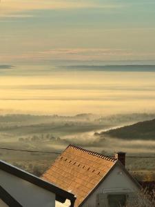 - une vue sur un champ de brumeux avec une maison dans l'établissement Kiskacsa Dörgicse, à Mencshely