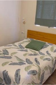 a bedroom with a bed with a green pillow and a window at LA FUENTE 2 in El Gastor +6 photos