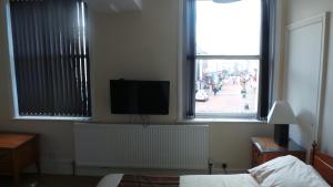a bedroom with a flat screen tv on a window at Victoria hotel in Holywell
