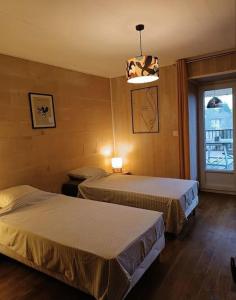 a hotel room with two beds and a window at Gite "La belle échappée" à 5 minutes du lac in Clairvaux-les-Lacs