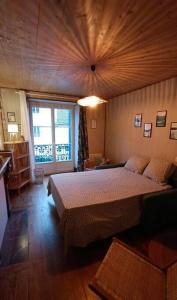 um quarto com uma cama grande e um tecto em madeira em Gite "La belle échappée" à 5 minutes du lac em Clairvaux-les-Lacs