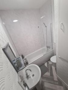 a bathroom with a sink and a toilet and a tub at Home from Home in Manchester