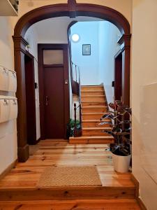 wejście do korytarza z drewnianymi podłogami i schodami w obiekcie Vila Queirós - Cozy&Sweet w Lizbonie
