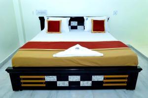 a large bed with a black and white comforter at JK Home Stay in Tirupati