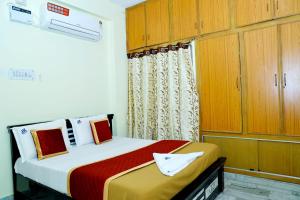 a bedroom with a bed and wooden cabinets at JK Home Stay in Tirupati
