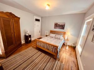 1 dormitorio con 1 cama y armario de madera en Laurel River Club Bed & Breakfast or LRCBNB, en Dryfork