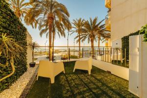 a balcony with two chairs and palm trees at HOSTAL LUXURY NIT I DIA in Altea