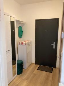 a black door in a room with a refrigerator at Apartmán Alicante in Dunajská Streda +9 photos