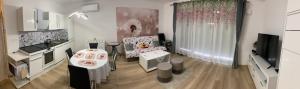 uma pequena sala de estar com uma mesa e uma cozinha em Apartmán Alicante em Dunajská Streda
