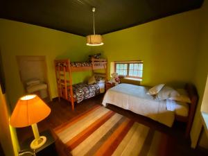 ein Schlafzimmer mit grünen Wänden, einem Bett und einer Lampe in der Unterkunft Casona Lo Aguirre in Talagante