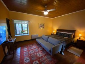 a bedroom with a bed and a couch and a tv at Casona Lo Aguirre in Talagante