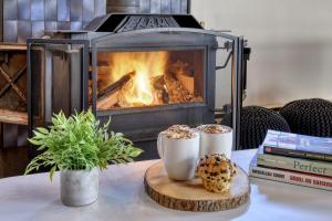 un camino con due tazze di cibo su un tavolo di Spacious cottage in forest with spa a La Macaza