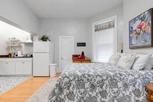 a white bedroom with a bed and a kitchen at G2 CENTRAL LOCATION museums FREE PARKING in Richmond