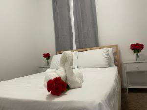 uma cama com toalhas brancas e uma flor vermelha em SUITE JESUS ROOM 3 em Paterson