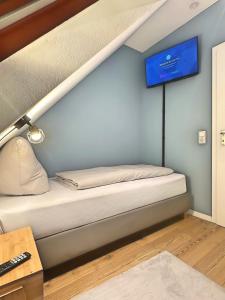 a bed in a room with a tv on the wall at Über den Dächern von Witten bis 6P in Witten