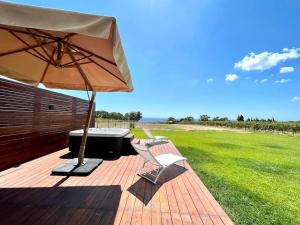 eine Terrasse mit einem Tisch, einem Sonnenschirm und Stühlen in der Unterkunft Villa Maria in Castelvetrano Selinunte