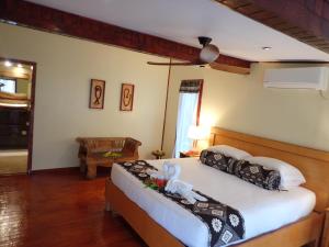 Sau Bay Resort & Spa في Waiyevo: غرفة نوم بسرير كبير وغرفة مع طاولة