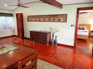 a living room with a dining room table and a mirror at Sau Bay Resort & Spa in Waiyevo