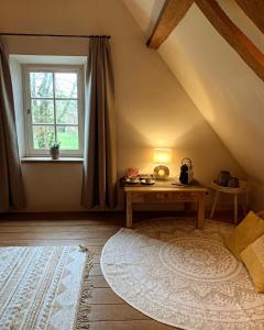 uma sala de estar com uma mesa e uma janela em Hamiora wellness B&B em Deinze