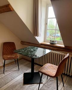 1 mesa y 2 sillas en una habitación con ventana en Hamiora wellness B&B, en Deinze