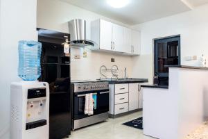 a kitchen with white cabinets and a stove top oven at Sylver Harbour 2 Bedroom Apartment in Nairobi