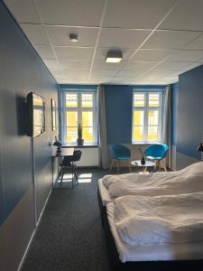 a hotel room with a bed and chairs and windows at Blue Double Room 6 On Pedestrian Street Saeby in Sæby