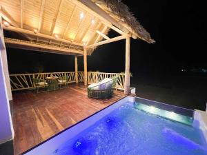 una terraza al aire libre con piscina por la noche en Jurema Dourada en Beberibe