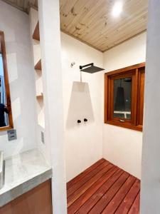 Habitación con suelo de madera y ventana. en Jurema Dourada en Beberibe