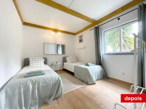 1 dormitorio con 2 camas y ventana en Villas Pedroso: nature, mountains and the ocean, en Cascais