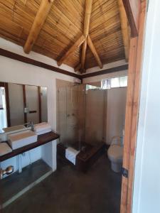 a bathroom with a shower and a sink and a toilet at Hoja de Palma Bungalows in Canoas De Punta Sal