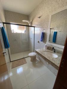 a bathroom with a shower and a toilet and a sink at Casa Por do Sol in Águas de Santa Barbara