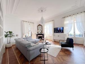 a white living room with a couch and a tv at Montreux Luxury Suite in Montreux