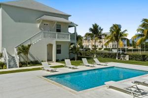 a villa with a swimming pool and lounge chairs at Chesapeake Place @ Palm Cay Resort in Nassau