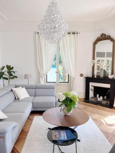 un soggiorno con divano, tavolo e lampadario pendente di Montreux Luxury Suite a Montreux