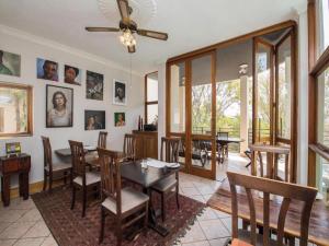 - une salle à manger avec une table, des chaises et des fenêtres dans l'établissement Jopasso Guest House, à Pretoria