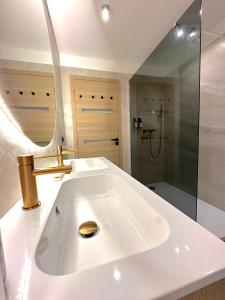 uma casa de banho branca com um lavatório e um chuveiro em MONACO # MENTON - F1GP MONACO - 6 PERSONS - 2 BEDROOMS - PARKING - CLIM - PREMIUM - Beach and Sun em Menton