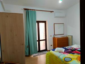 ein Schlafzimmer mit einem Bett, einer Kommode und einem Fenster in der Unterkunft LIBECCIO "parcheggio privato, terrazzo, grande appartamento uso esclusivo" in Sapri