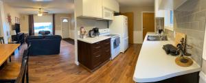 a large kitchen with white counters and a counter top at Mountain View Executive Suite in Grande Cache