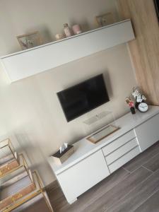 een woonkamer met een flatscreen-tv aan de muur bij Appartement Seyana - Agréable avec jardin et grande Véranda - Proche mer in Cagnes-sur-Mer