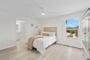 a white bedroom with a bed and a window at Lake Murex Dream in Sanibel