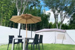 uma mesa e cadeiras debaixo de um guarda-sol ao lado de uma tenda em LUCY RESORT - Vacation STAY 77594v 