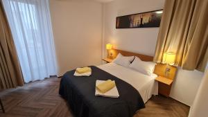 蒂米什瓦拉Jafar Resort 5的酒店客房的床上配有两个黄色枕头