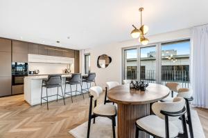 een keuken en een woonkamer met een tafel en stoelen bij Stylish 3BR Apt - Heart of Luxembourg - Jacuzzi in Luxemburg