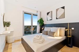 a bedroom with a large white bed with a window at Stylish 3BR Apt - Heart of Luxembourg - Jacuzzi in Luxembourg