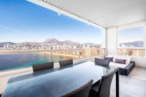 ein Esszimmer mit Tisch und Stühlen und einem großen Fenster in der Unterkunft Gemelos 28-16D Deluxe Apartment Levante Beach in Benidorm
