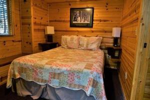 1 dormitorio con 1 cama en una cabaña de madera en Cold Springs Resort, en Camp Sherman