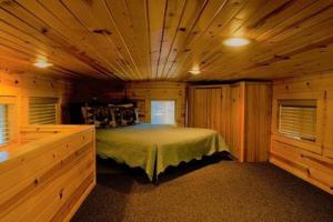1 dormitorio con 1 cama en una habitación de madera en Cold Springs Resort, en Camp Sherman