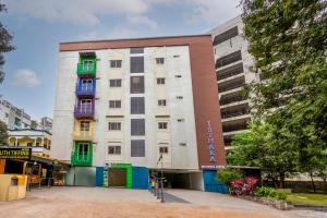 a white building with green doors and windows at Smart Stay by Isthara Vega. Kondapur in Kondapur