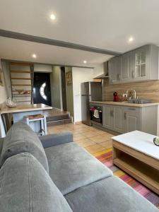 a living room with a couch and a kitchen at Charmant appartement in Béguey