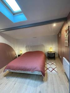 a bedroom with a bed and a skylight at Charmant appartement in Béguey